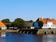 Herregården Søbygaard på Ærø med stråtag spejlet i voldgraven